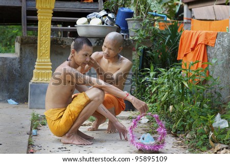 SIEM REAP, CAMBODIA-JAN 22: Buddhist monk shaves head of another monk at Wat Atwea in Siem Reap on Jan. 22, 2012. Buddhism is currently estimated to be the faith of 96% of the Cambodian population
