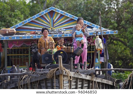 SIEM REAP, CAMBODIA-JAN 23: Cambodian family on their floating home on Tonle Sap Lake in Siem Reap, Cambodia on January 23,2012. Tonle Sap is the largest freshwater lake in SE Asia peaking at 16k km2