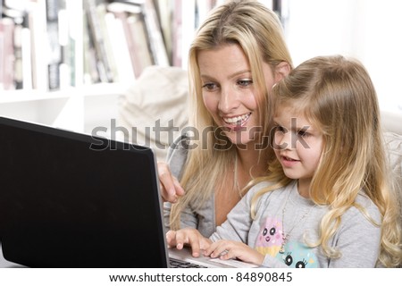 mother and daughter having fun with the computer at home