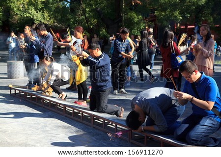 BEIJING-OCT 2: Worshippers holding incense sticks pray at Yonghegong Lama Temple during National Day holiday on Oct. 2,2013 in Beijing, China. China's celebrates 64th anniversary of founding