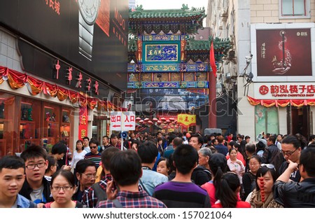 BEIJING - OCT 4: People crowd at the main entrance of the famous Wangfujing snack street during National Day holiday on Oct. 4, 2013 in Beijing, China. China\'s celebrates 64th anniversary of founding