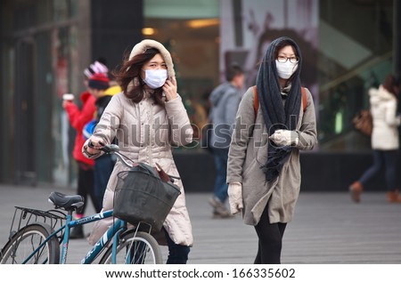 BEIJING-DEC 8: People with face masks are seen on Dec 8,2013 in Beijing, China.  104 cities in China suffered from severe air pollution on Dec7, Beijing was among that hit the hardest