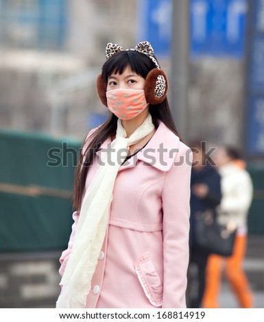BEIJING, CHINA - DEC 8, 213: A woman is seen with face mask; a high-ranking environmental official has estimated cleaning up China\'s air pollution will cost 1.75 trillion yuan between 2013 and 2017