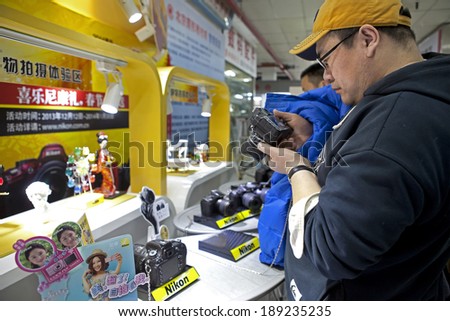 BEIJING, CHINA-JAN. 11, 2014: A man is seen taking a look at a Nikon camera; Nikon Corporation, also known as Nikon, is a Japanese multinational corporation specializing in optics and imaging products