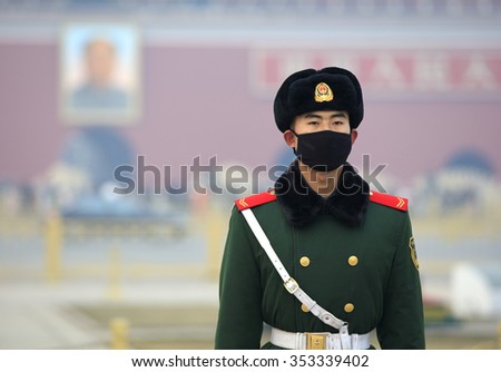 BEIJING, CHINA - DECEMBER 20, 2015: A Chinese military man wears a face mask at Tiananmen Square. Beijing issued a red alert for air pollution on Friday, its second red alert this month.