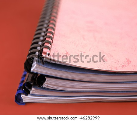 Close-up of a stack of spiral notebooks over white background