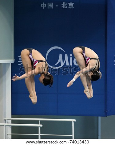 BEIJING - MARCH 25: He Zi and Wu Minxia of China perform during Women\'s 3m Springboard Synchro Final of the FINA/Midea Diving World Series 2011 on March 25, 2011 in Beijing, China.