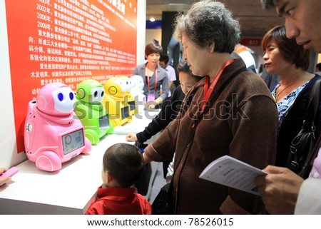 BEIJING-MAY 20: Visitors look at a robot that is on display for demonstration during the 14th China Beijing International High-tech Expo (CHITEC) on May 20, 2011 in Beijing, China.