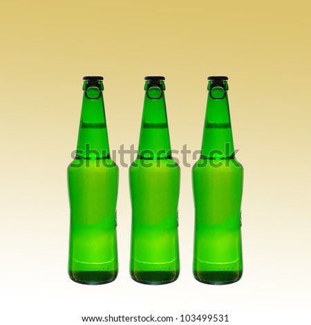 Three green beer bottles with caps on a yellow  background. Space for text
