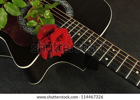 Black guitar and red rose