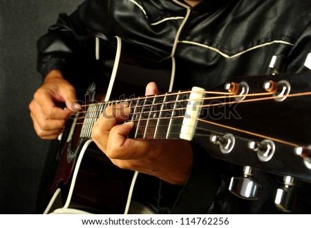 Man playing guitar on black background