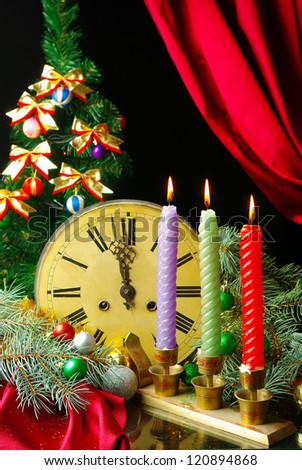 Three candles, old clock and decorated christmas tree