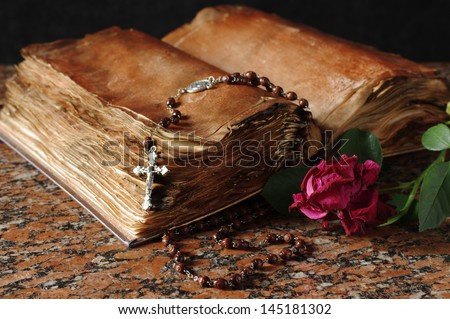 Old holy book, rose and rosary beads