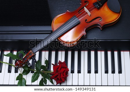 Piano keyboard, red rose and  violin