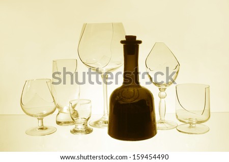 Broken glasses and bottle of wine in yellow