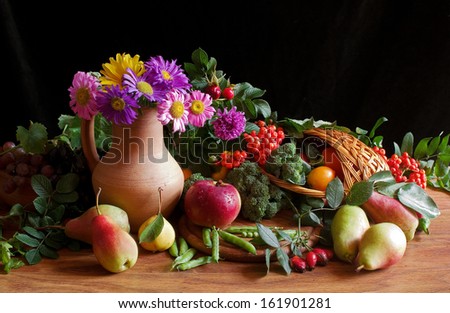 Composition with variety fruits, flowers and leaves in basket  on black