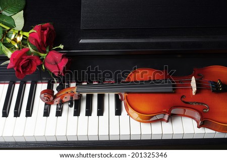 Piano keyboard, red roses and violin
