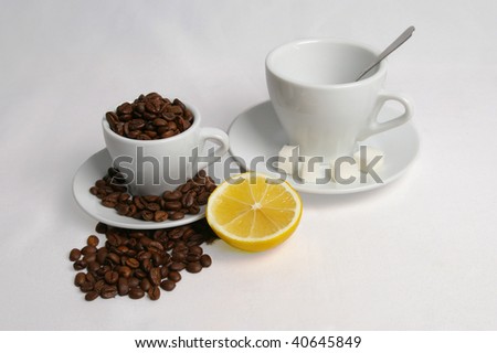 Coffee idea.Two cup of coffee with grains on white