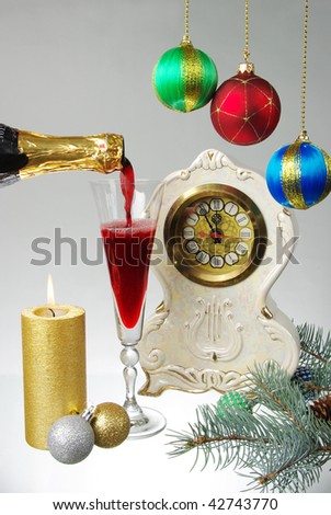Pouring red champagne, clock and candle