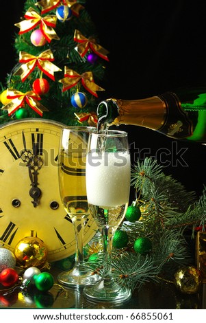 Pouring champagne  in front of clock and Christmas tree