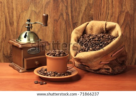 Cup of coffee with coffees sack over wooden background