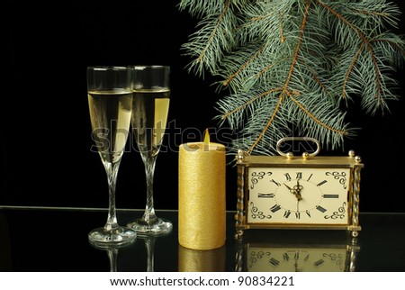 Two glasses of champagne, candle and old clock.