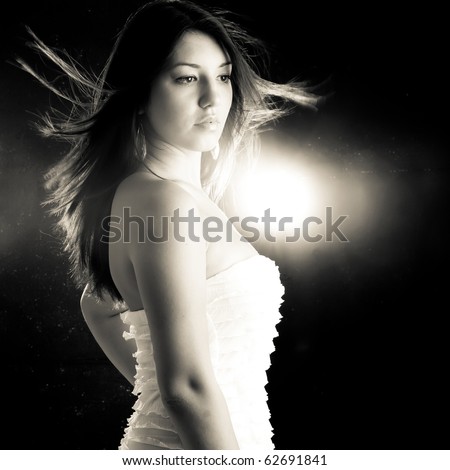 Toned image of a Beautiful girl in a white dress and dramatic disco-like lightning