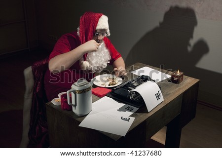 Santa Claus having a dinner break, eating by the work desk