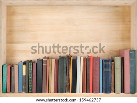 Old books on a wooden shelf.
