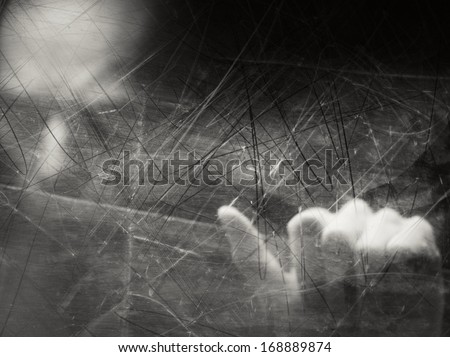 Spooky blurry human face behind dusty scratched glass
