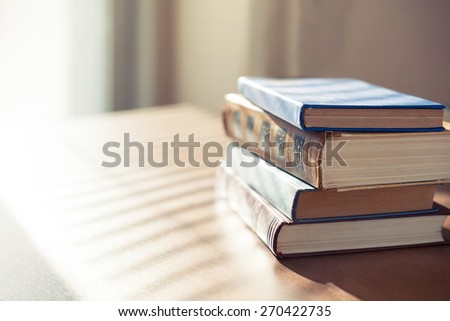Books on the table in front of sunlight. Shallow depth of field.