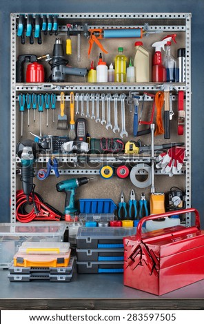 Garage tool rack with various tools and repair supplies on board and shelves.
