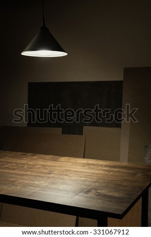 Lamp hanging over empty wooden table in workshop
