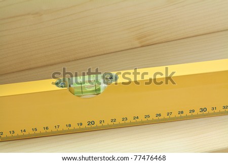 Yellow level tool on wood plank.