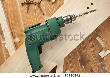 Electric drill on wooden board
