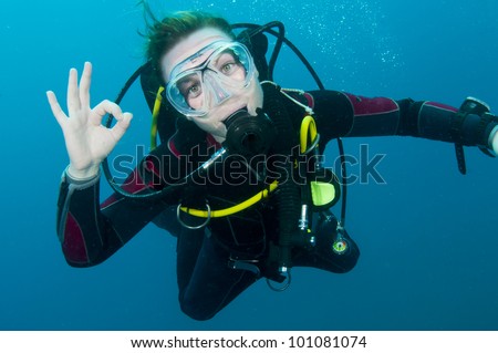 scuba diver makes OK sign underwater