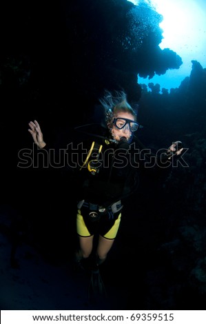 female scuba diver is in underwater cavern