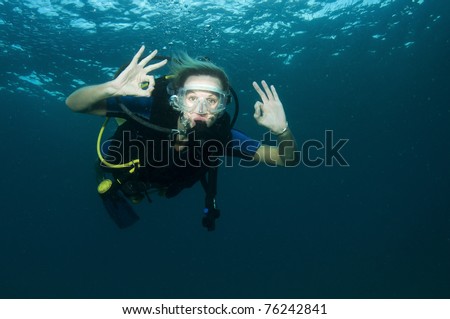 blonde female scuba diver in clear blue water