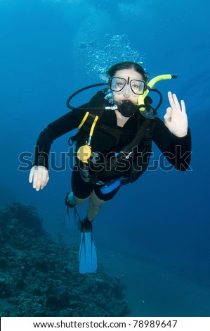Scuba divers enjoy the dive and make OK sign