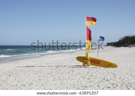 Australian Beach Surf Rescue surfboard and flags on Bribie Island beach, Queensland, Australia