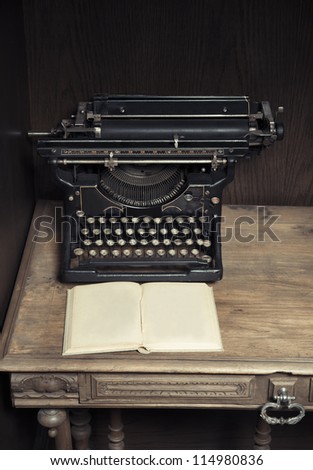 Antique typewriter on desk with book