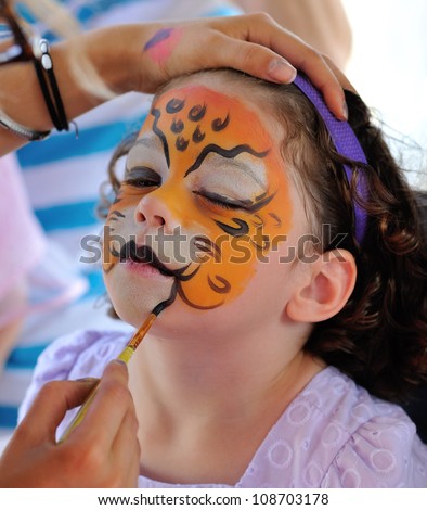 Pretty girl with face painting of a jaguar