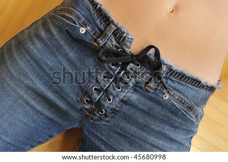 Close up of young woman wearing lace-up low rise denim blue jeans