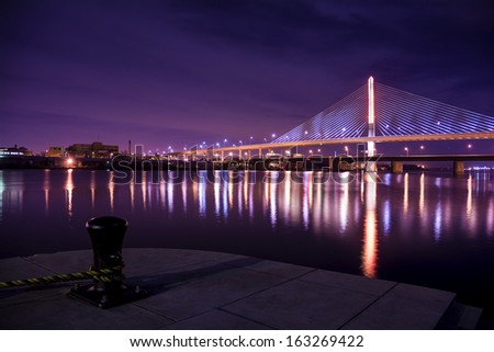 Night view of the Veterans\' Glass City Skyway bridge in Toledo Ohio.  The bridges center pylon is lit up with LED lighting and the stainless steel cables are lit with floodlights.