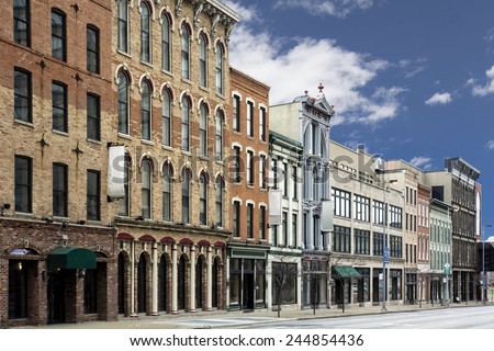 A photo of a typical small town main street in the United States of America. Features old brick buildings with specialty shops and restaurants.