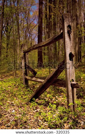 A broken down split rail fence in the forest.