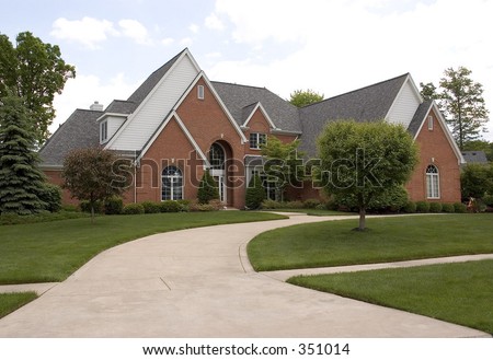 A brick house with a steep roof-line and a circular drive that welcomes you right to the front entrance.