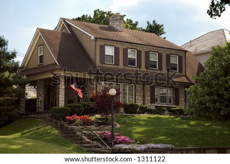 A beautiful Colonial style home with the American flag and beautiful flowers on a nice spring day. Located in historic Lancaster Ohio.