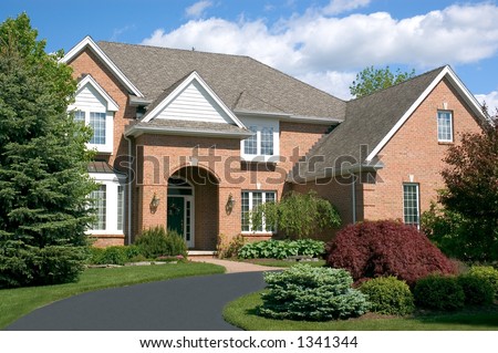 Beautiful brown two story brick home with a circular driveway. Typical new home in the suburbs of the United States. Just one of many home or house photos in my gallery.
