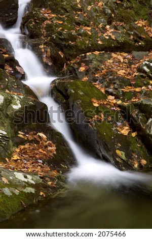 A small secluded waterfall in the forests of West Virginia. Taken in autumn with the fallen leaves scattered over the moss covered boulders.